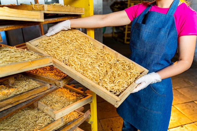 Fábrica de pasta Producción de pasta Macarrones Krafted Trabajador con caja de madera con pasta