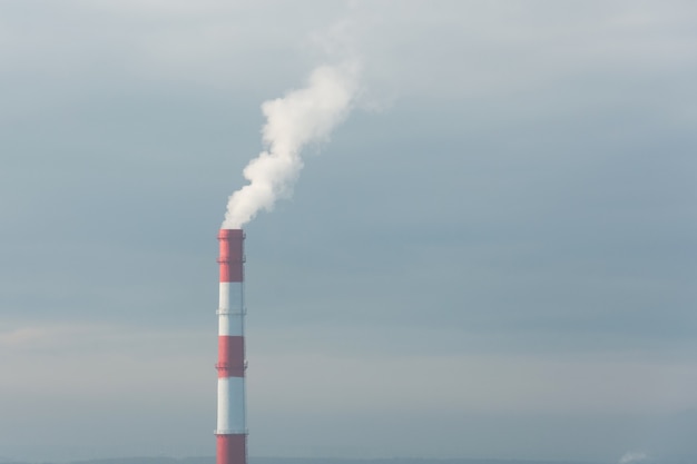 Fábrica de pipas rojas y blancas en la atmósfera contaminada de la ciudad.