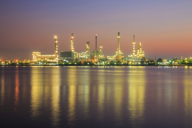 Fábrica de refinería de petróleo en silueta y cielo del amanecer