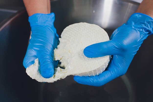 Foto fabricação tradicional de queijo em uma pequena empresa hands cheese maker closeup top view