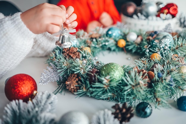 Fabricante de coronas navideñas de ramas de pino para vacaciones Clase magistral sobre cómo hacer adornos decorativos Niños en la clase magistral de la corona navideña