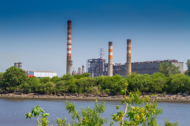 Fabrik am Fluss vor klarem blauen Himmel