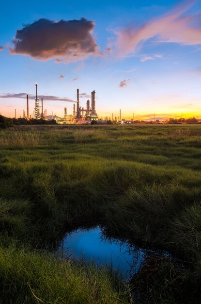 Fabrik auf dem Feld gegen den Himmel während des Sonnenuntergangs in der Ölraffinerie