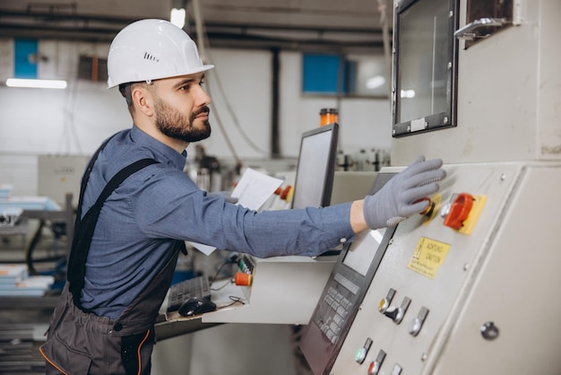 Fabrikarbeiter, der industrielle Maschinen für die Herstellung von Fenstern und Türen aus Aluminium und PVC bedient