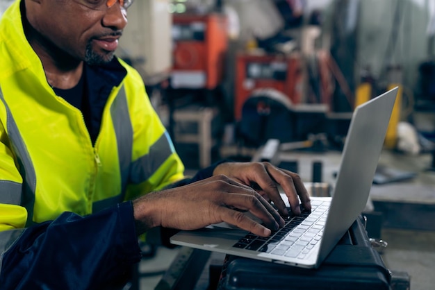 Fabrikarbeiter, der mit einem Laptop arbeitet, um eine Checkliste für geschickte Verfahren zu erstellen