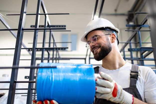 Fabrikarbeiter, der Textilmaterial in der Fabrik hält