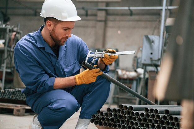 Foto fabrikarbeiter in blauer uniform ist im innenraum