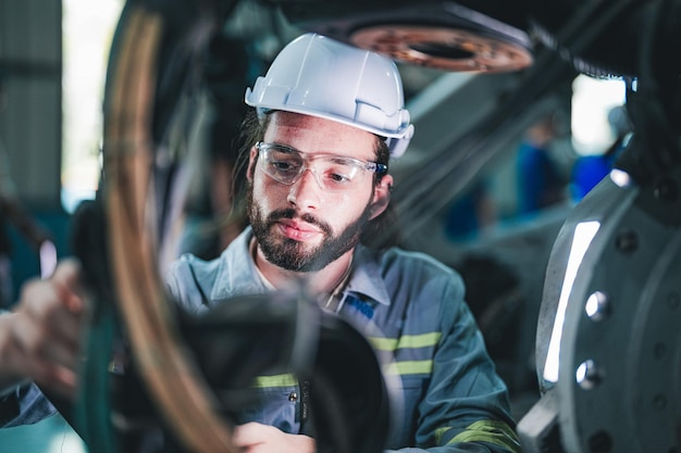 Fabrikarbeiter-Ingenieur inspiziert elektrische Kabel an der Maschine. Arbeiter arbeitet an schwerer Maschine in der Fabrik