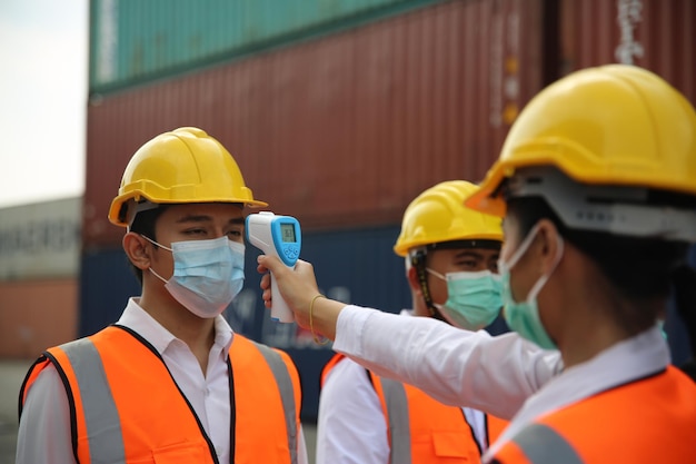 Fabrikarbeiter mit Gesichtsmasken, die vor dem Corona-Virus geschützt sind, führen die Qualitätskontrolle der Produktion in der Fabrik durch Menschen, die während der COVID19-Pandemie arbeiten