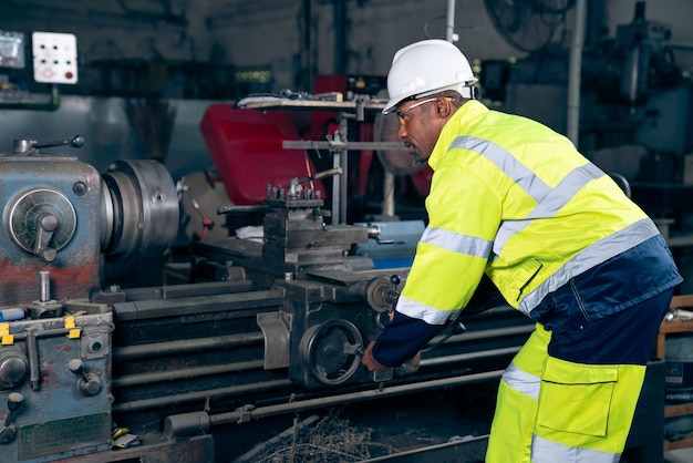 Fabrikarbeiter oder Ingenieur erledigen Maschinenarbeiten in einer geschickten Fertigungswerkstatt