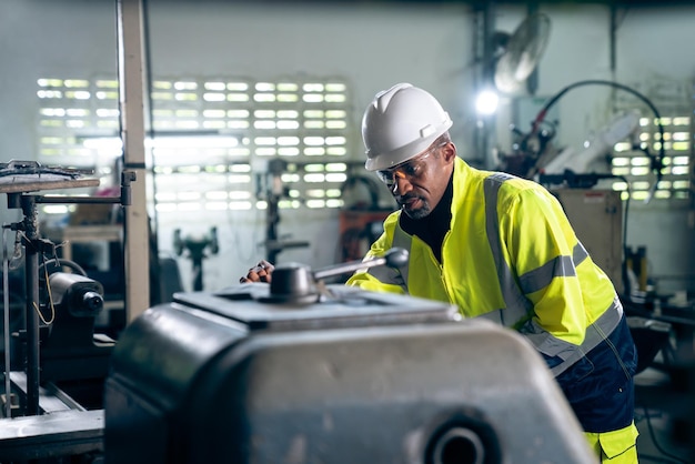 Fabrikarbeiter oder Ingenieur erledigen Maschinenarbeiten in einer geschickten Fertigungswerkstatt