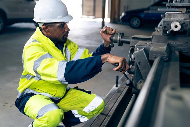 Fabrikarbeiter oder Ingenieur erledigen Maschinenarbeiten in einer geschickten Fertigungswerkstatt