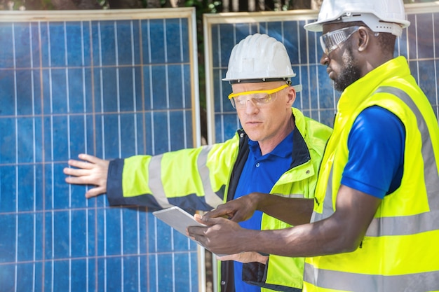 Fabrikarbeiter zeigen und überprüfen Solarzellenmodule auf nachhaltige Technologie
