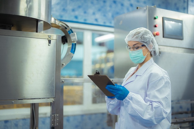 Fabrikarbeiterin überprüft Maschinenanlagen in der Industriefabrik