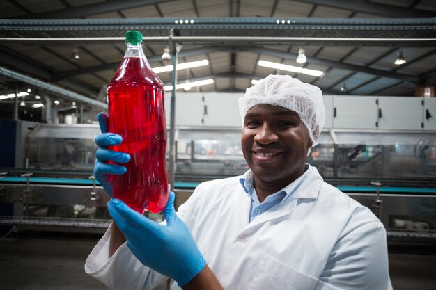 Fabrikingenieur hält eine Flasche Saft