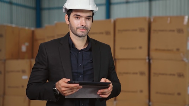 Fabrikleiter mit Tablet-Computer im Lager oder in der Fabrik. Industrie- und Supply-Chain-Management-Konzept.