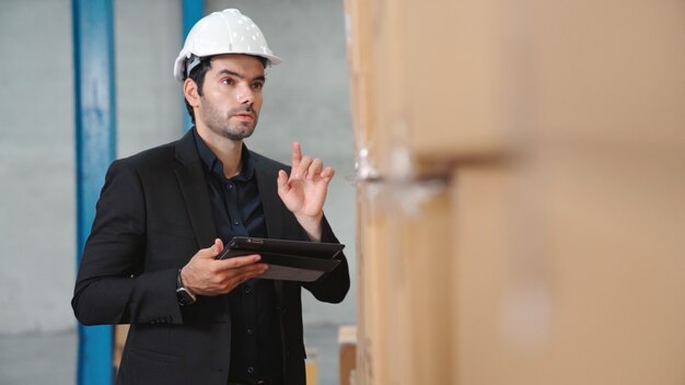 Fabrikmanager mit tablet-computer im lager oder in der fabrik. industrie- und supply-chain-management-konzept.