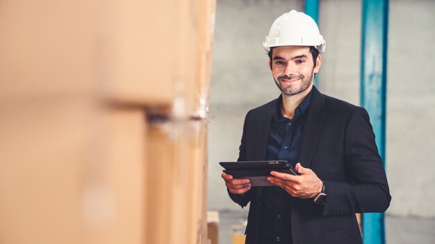 Fabrikmanager mit Tablet-Computer im Lager oder in der Fabrik