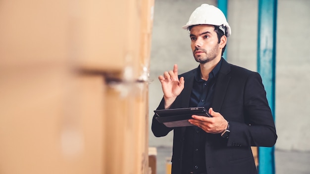 Fabrikmanager mit Tablet-Computer im Lager oder in der Fabrik