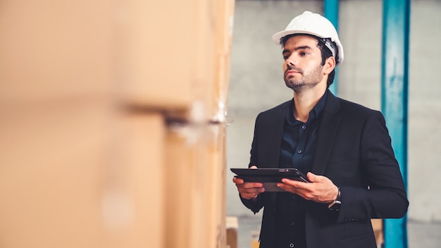 Fabrikmanager mit Tablet-Computer im Lager oder in der Fabrik