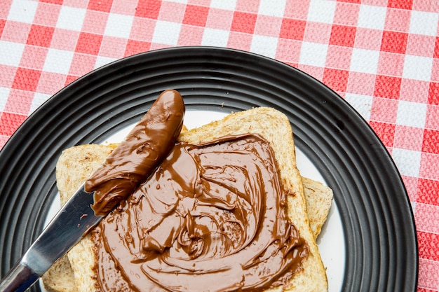 Faca com chocolate avelã espalhado no pão