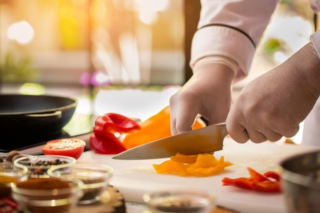 Faca corta colorau amarela. Pedaços de pimentão. Prepare uma salada com vegetais suculentos. Verdadeiro profissional da cozinha.