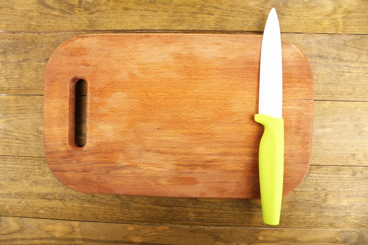 Foto faca de cozinha e prancha de cortar em mesa de madeira