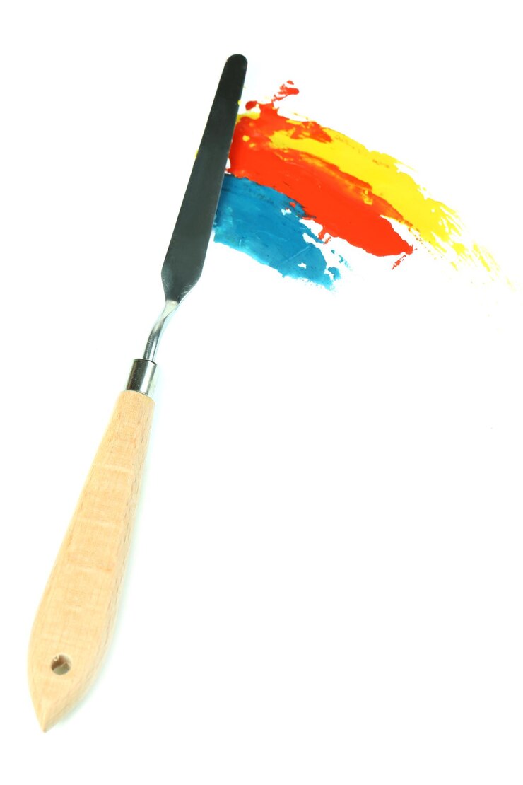 Foto faca de paleta de pintura com tintas isoladas em branco