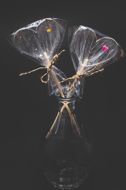 Faça dieta de pirulitos encaracolados. Transparente e com elementos brilhantes. Em uma vara. Sobre um fundo preto.