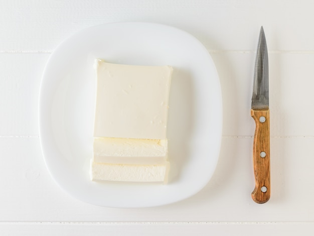 Faca e queijo sérvio em uma tigela branca sobre uma mesa branca