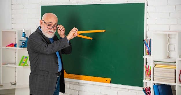 Foto faca oque eu faco. estude matemática para obter bons resultados. professor de homem sênior usar ferramenta de bússola. homem tutor barbudo desenhar com bússola no quadro-negro. de volta à escola. conceito de ferramentas gráficas matemáticas. em direção ao conhecimento.