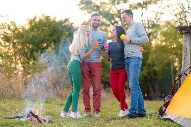 Faça um piquenique com os amigos junto à lareira. Amigos da empresa tendo um fundo de natureza de piquenique de caminhada. Amigos contam histórias. Piquenique de verão. Divirta-se com os amigos