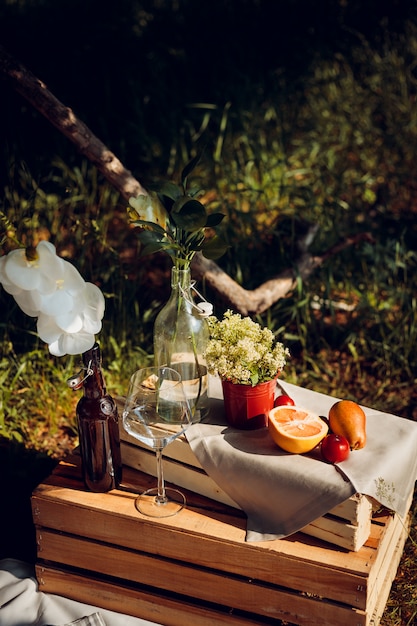 Faça um piquenique na floresta com vinho, frutas e baguete.