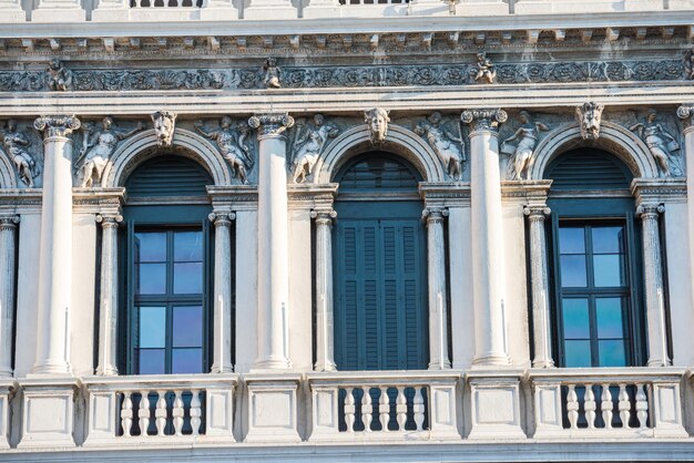 Foto facada con ventanas, columnas y decoraciones de un antiguo edificio en la plaza de san marco, venecia, italia