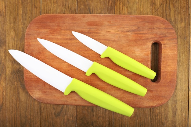 Foto facas de cozinha e tábua de cortar na mesa de madeira