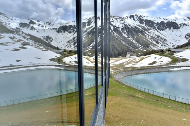 Fachada acristalada con reflejo de lago.