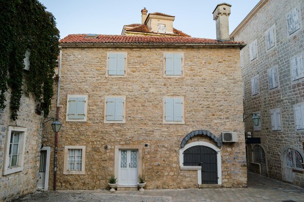 Fachada de la antigua casa de piedra con ventanas de guillotina de madera cerradas por la noche