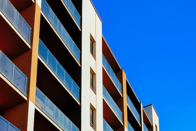 Fachada de casa de apartamentos residenciales con un lugar vacío para el espacio de copia. Cielo azul en el fondo.