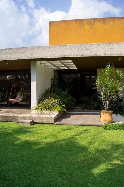 Fachada de una casa moderna con grapa de piedra que envuelve las ventanas pintadas en herrajes de entrada de metal gris