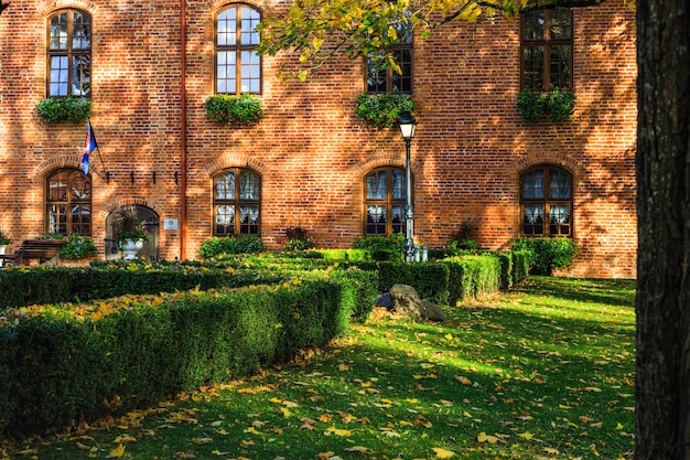 La fachada del castillo señorial de estilo gótico-renacentista y jardín en un otoño soleado