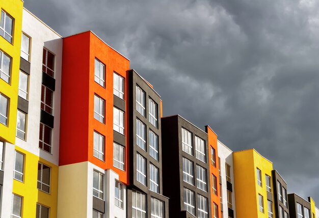 Fachada colorida de edifícios modernos contra um céu tempestuoso