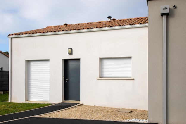 Fachada de casa moderna com porta de entrada e obturador de janelas fechadas