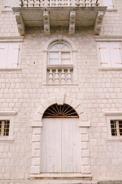 Fachada de um edifício com portadas em arco nas janelas e uma varanda de pedra