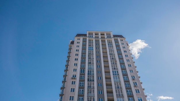 Fachada de um fragmento de construção residencial vista de baixo ângulo contra o céu