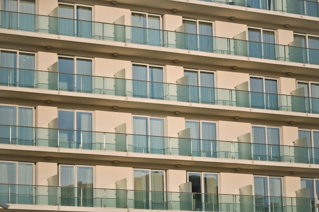 fachada de um grande hotel moderno com janelas e varandas abertas à luz do sol