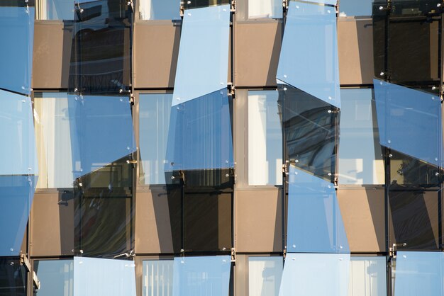 Fachada de vidro em estilo de alta tecnologia. Edifício moderno com geometria irregular.