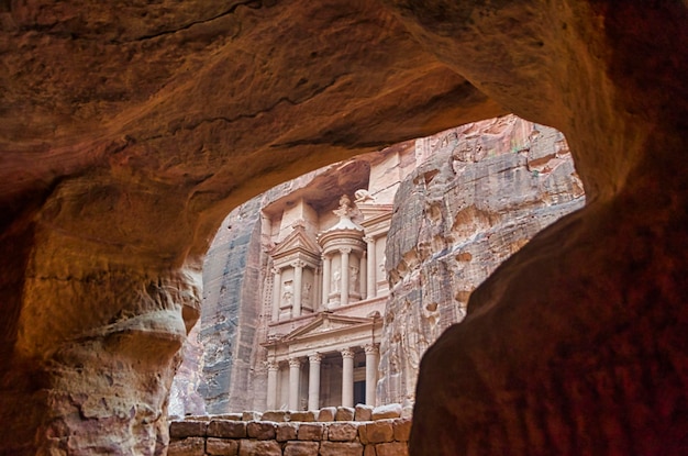 Fachada do famoso Tesouro ou al Khazna na antiga cidade nabateana de Petra vista de dentro de uma caverna esculpida