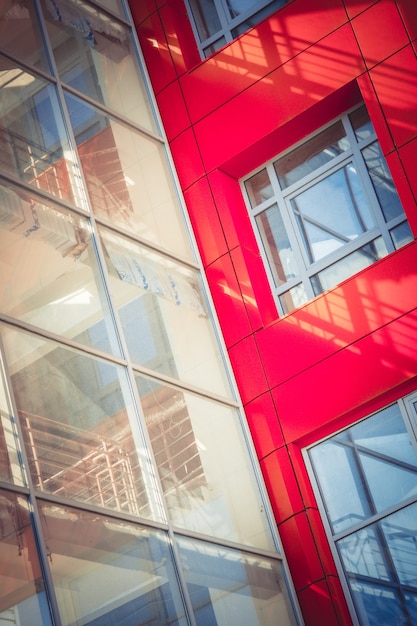 Fachada do novo edifício moderno com parte transparente e parede vermelha