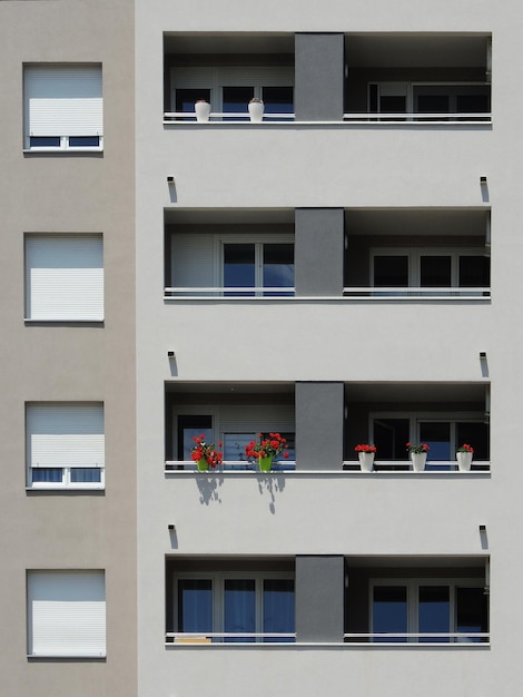 Fachada do prédio de apartamentos moderno uma varanda com flores