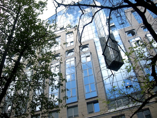 Fachada de un edificio acristalado con reflejo de cielo azul